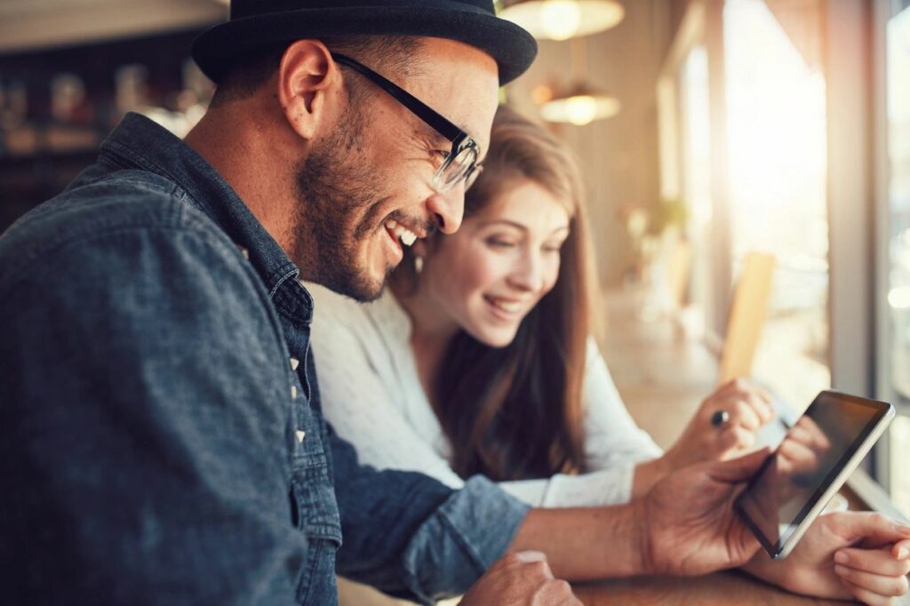 A man and woman looking at an ipad.