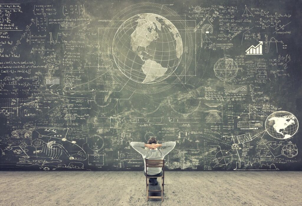 A person sitting in front of a chalkboard with a globe drawn on it.